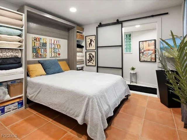 a bedroom with a large bed and a flat tv screen