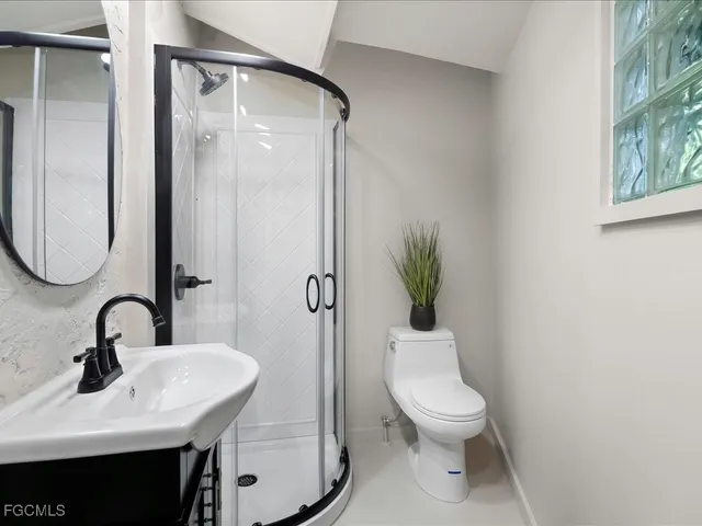 a bathroom with a toilet a sink and a mirror