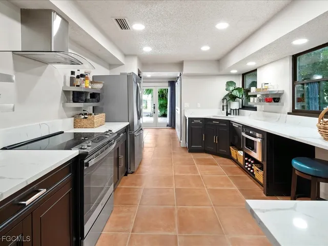 a large kitchen with stainless steel appliances a sink and stove