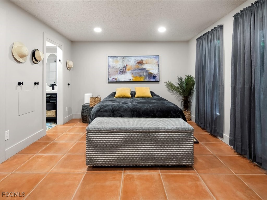 1046 Sperling Avenue Naples, FL 34103 - Photo 8 of 18 a bedroom with a large bed and a chandelier