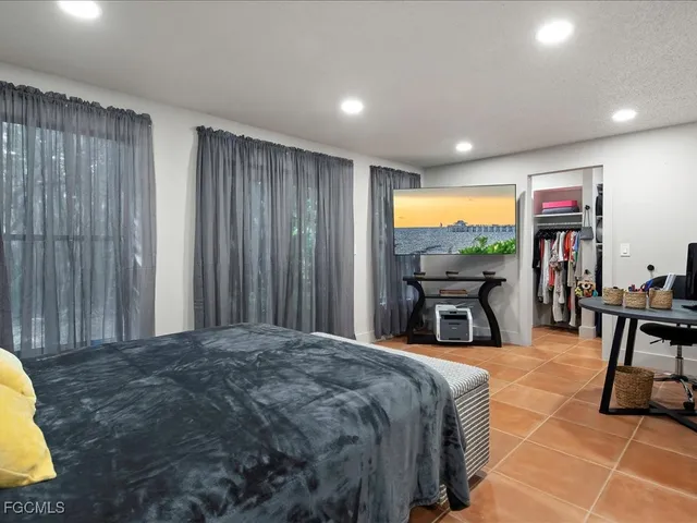 a bed sitting in a spacious bedroom next to a window