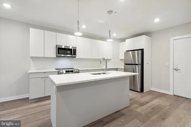 a kitchen with kitchen island a sink stainless steel appliances and cabinets