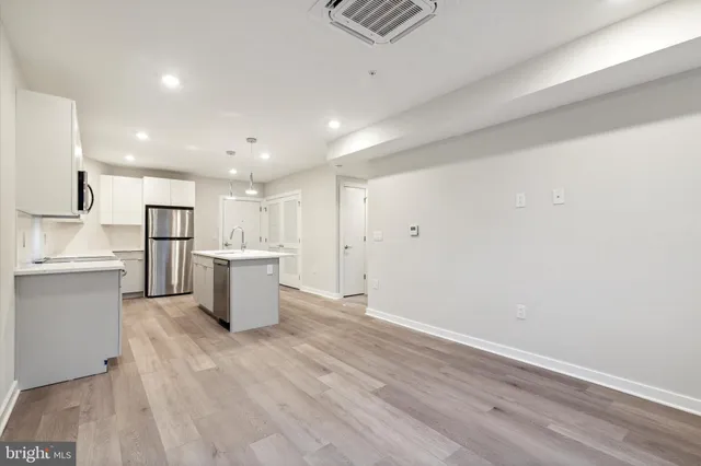 a view of kitchen view wooden cabinets and stainless steel appliances