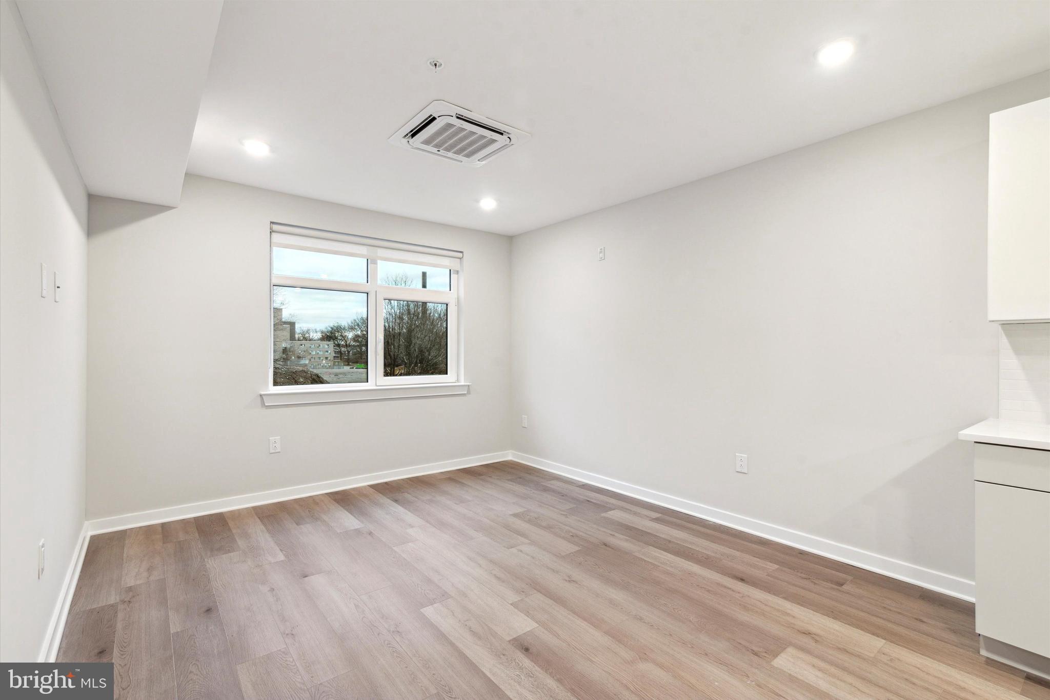 3449 Scotts Lane, Unit B303 Philadelphia, PA 19129 - Photo 9 of 9 an empty room with wooden floor and windows