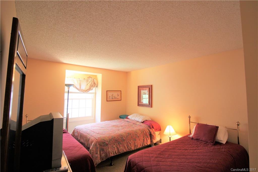 303 Riddle Cove Road, Unit 330 Maggie Valley, NC 28751 - Photo 14 of 24 a bedroom with two beds and painting on the wall