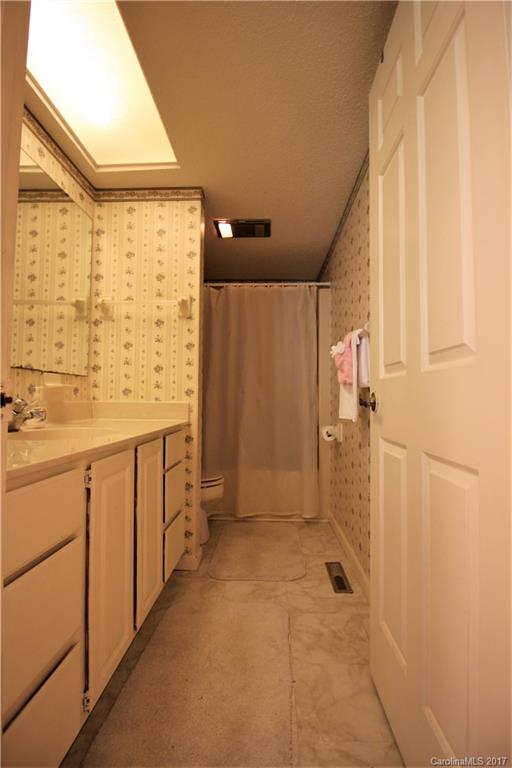 303 Riddle Cove Road, Unit 330 Maggie Valley, NC 28751 - Photo 10 of 24 a bathroom with shower sink and mirror