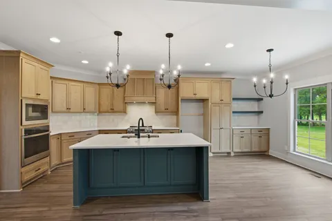 a kitchen with kitchen island white cabinets and stainless steel appliances