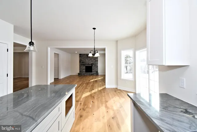 a view of a hallway with wooden floor and a cabinet
