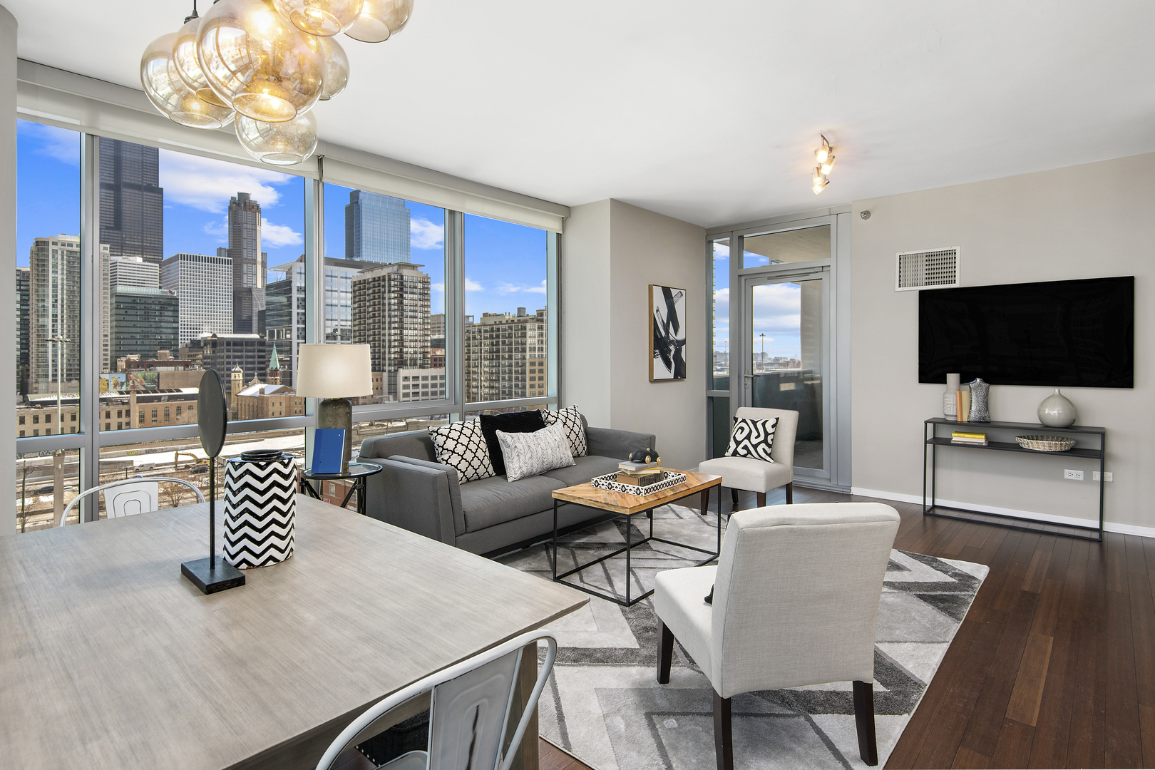 123 South Green Street, Unit 903B Chicago, IL 60607 - Photo 4 of 22 a living room with furniture a flat screen tv and kitchen view
