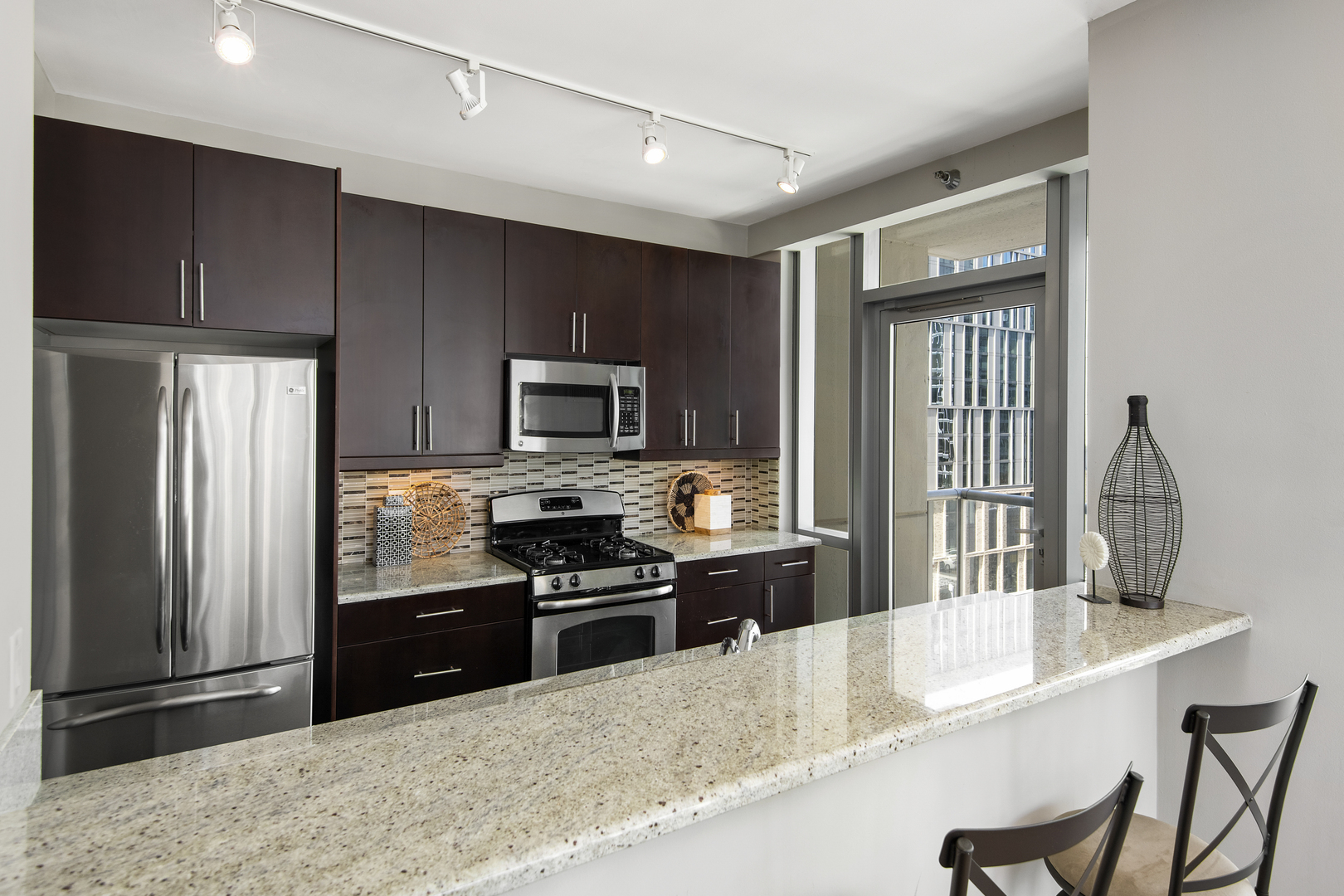 123 South Green Street, Unit 903B Chicago, IL 60607 - Photo 7 of 22 a kitchen with stainless steel appliances granite countertop a refrigerator a stove top oven a sink and dishwasher