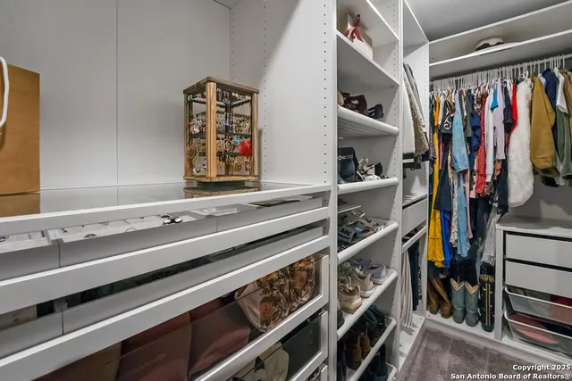 a view of walk in closet with clothes and shoes