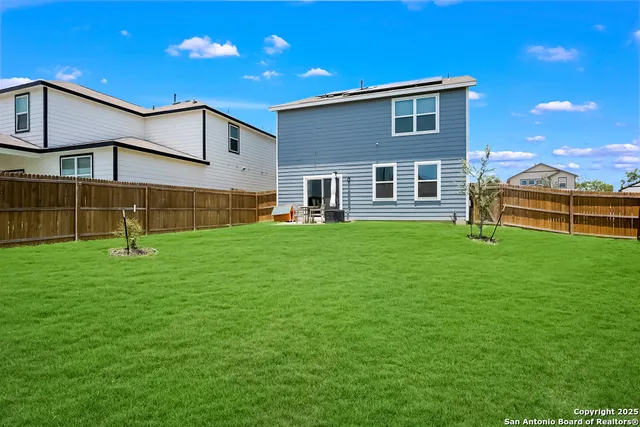 a backyard of a house with table and chairs