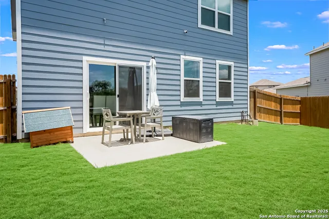 a view of a house with a backyard and a patio
