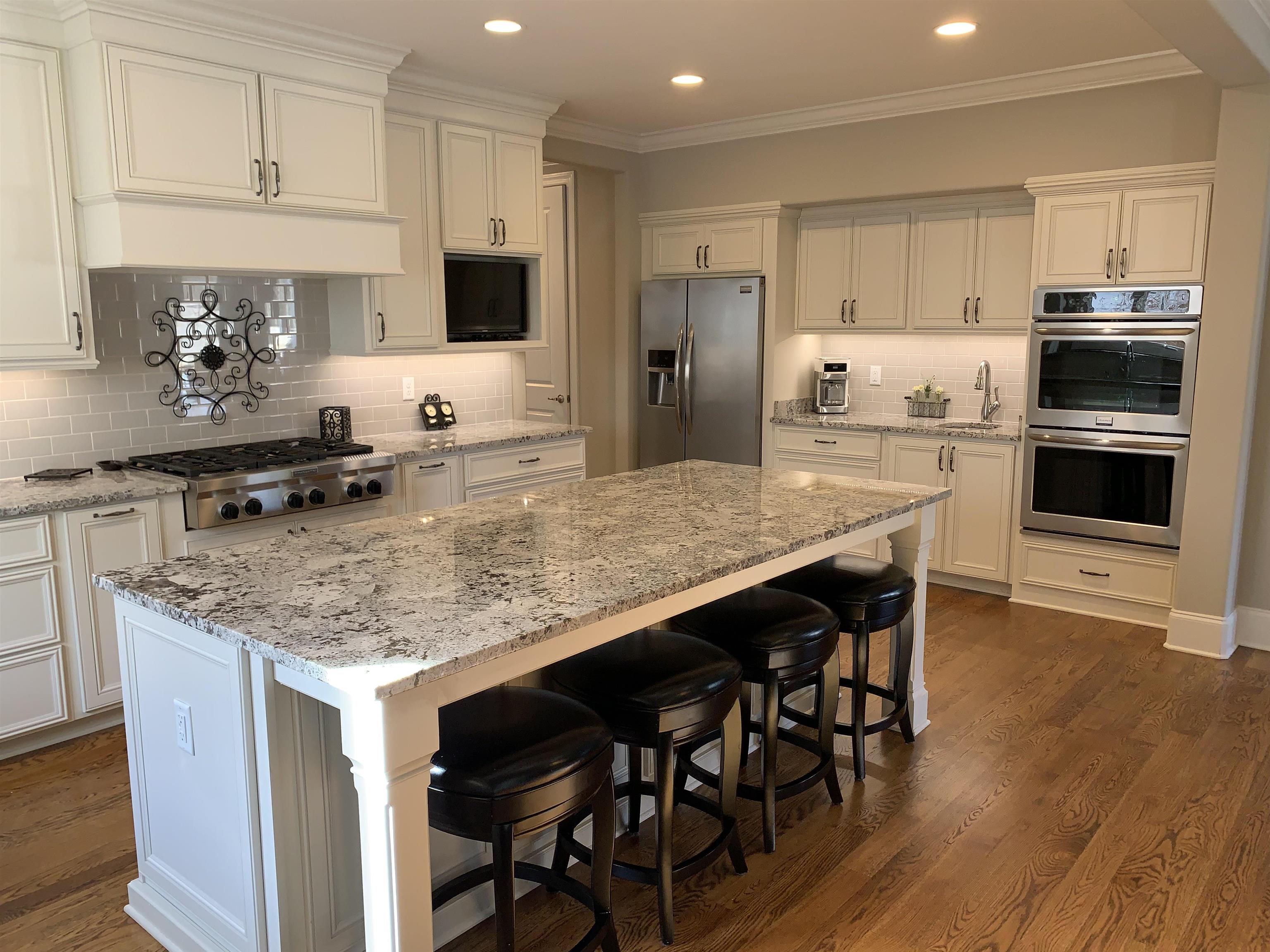 56 South Fernway Road Memphis, TN 38117 - Photo 7 of 25 a kitchen with stainless steel appliances granite countertop a stove a sink a microwave a refrigerator and white cabinets