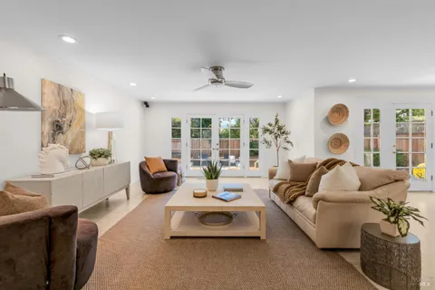 a living room with furniture ceiling fan and a large window