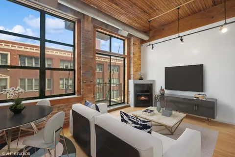 a living room with furniture a flat screen tv and a floor to ceiling window