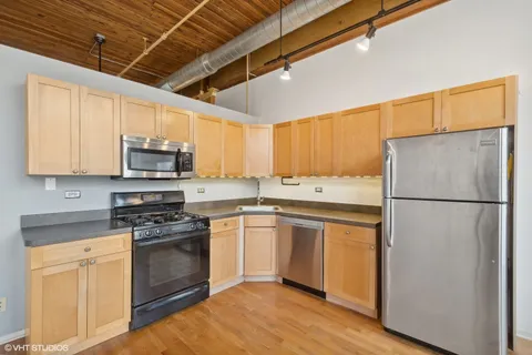 a kitchen with stainless steel appliances a refrigerator sink and microwave