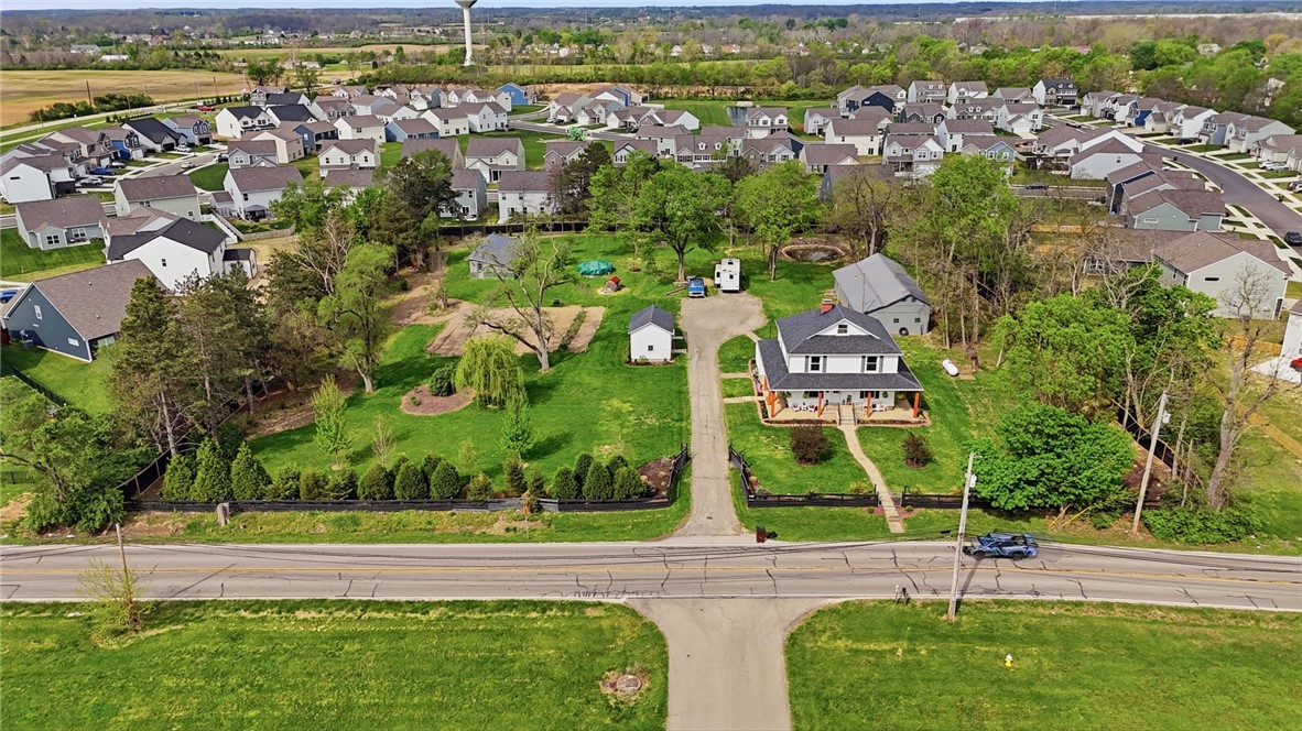 6155 North Union Road Clayton, OH 45315 - Photo 5 of 59 This captivating aerial view showcases a home amidst lush greenery and a tranquil neighborhood setting.