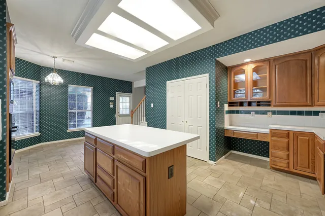 a kitchen with stainless steel appliances granite countertop a stove top oven a sink and a refrigerator