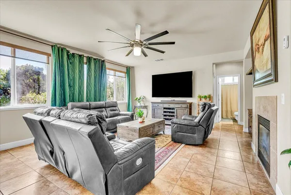 a living room with furniture a fireplace and a flat screen tv