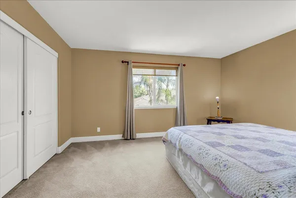 a spacious bedroom with a bed and a window