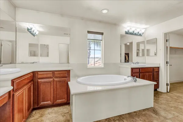 a bathroom with a sink double vanity mirror and a bathtub