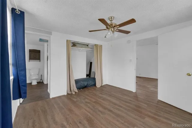 a view of a livingroom with wooden floor and a ceiling fan