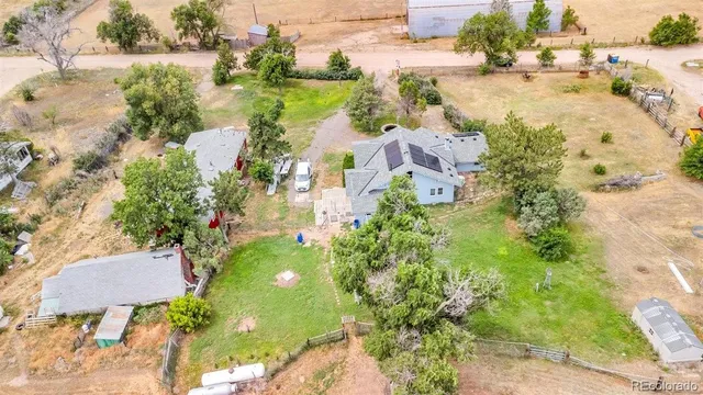 an aerial view of residential houses with outdoor space and trees all around
