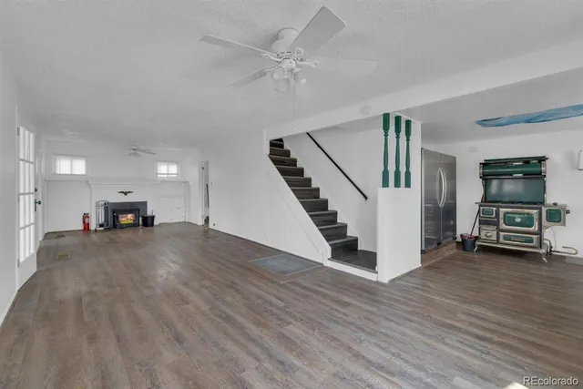 a view of a livingroom with wooden floor and furniture