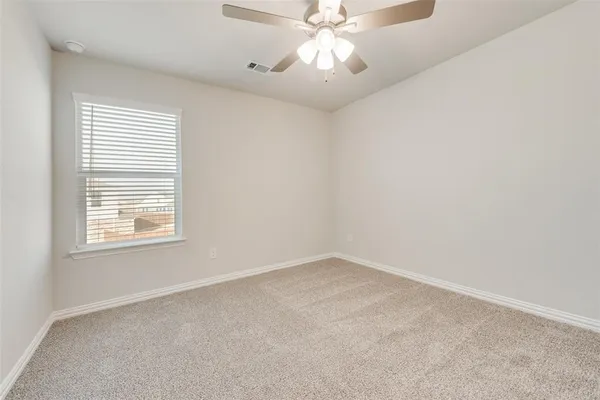 an empty room with a window and a fan