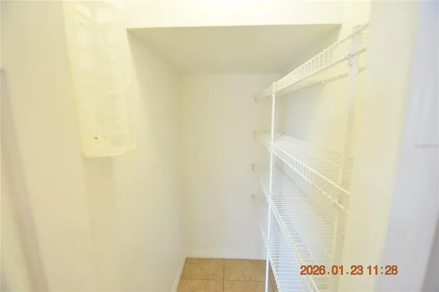 an empty room with windows and chandelier fan