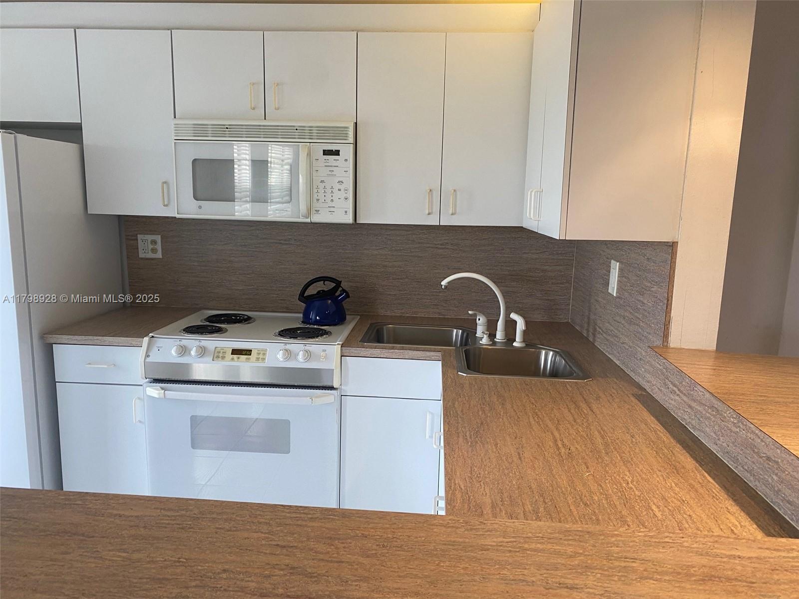 1400 Southwest 27th Avenue, Unit 202 Miami, FL 33145 - Photo 14 of 34 a view of a kitchen with stove and cabinets