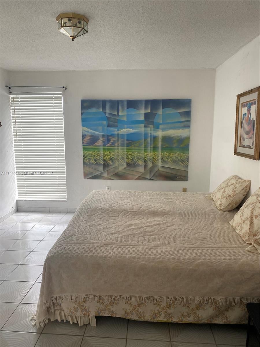 1400 Southwest 27th Avenue, Unit 202 Miami, FL 33145 - Photo 18 of 34 a bedroom with a bed and a window