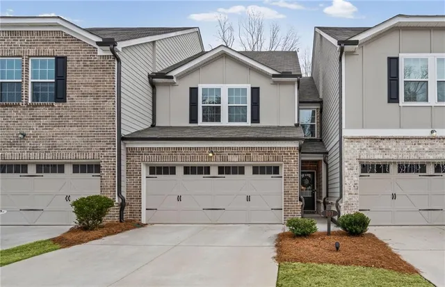 a front view of a house with a yard and potted plants