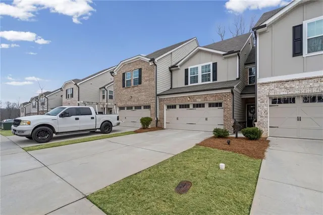 a view of a house with a yard and parking space