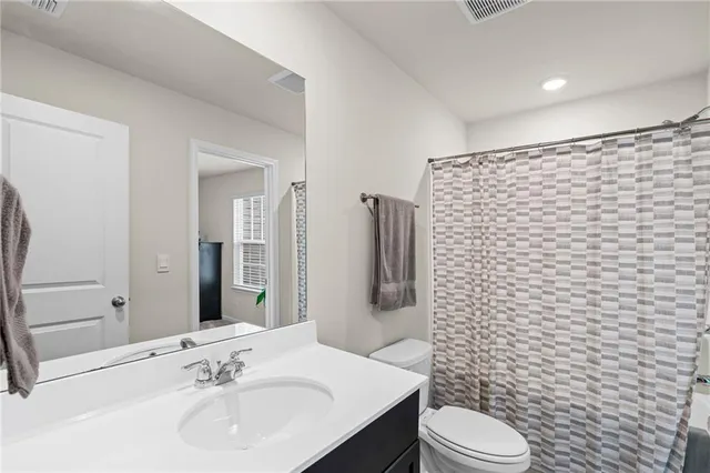 a bathroom with a sink a toilet and shower curtain