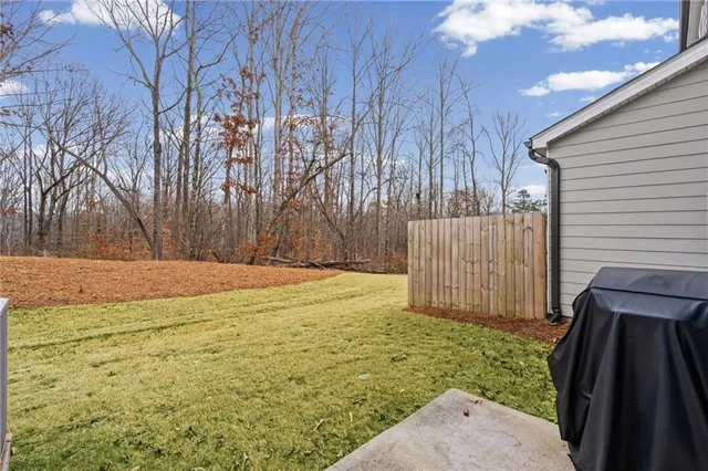 a view of backyard with wooden fence