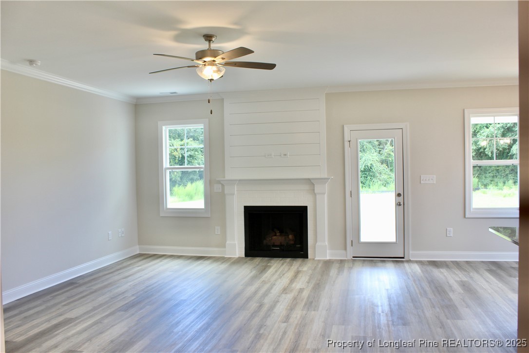 112 Surles Road Benson, NC 27504 - Photo 11 of 40 an empty room with wooden floor fireplace and windows