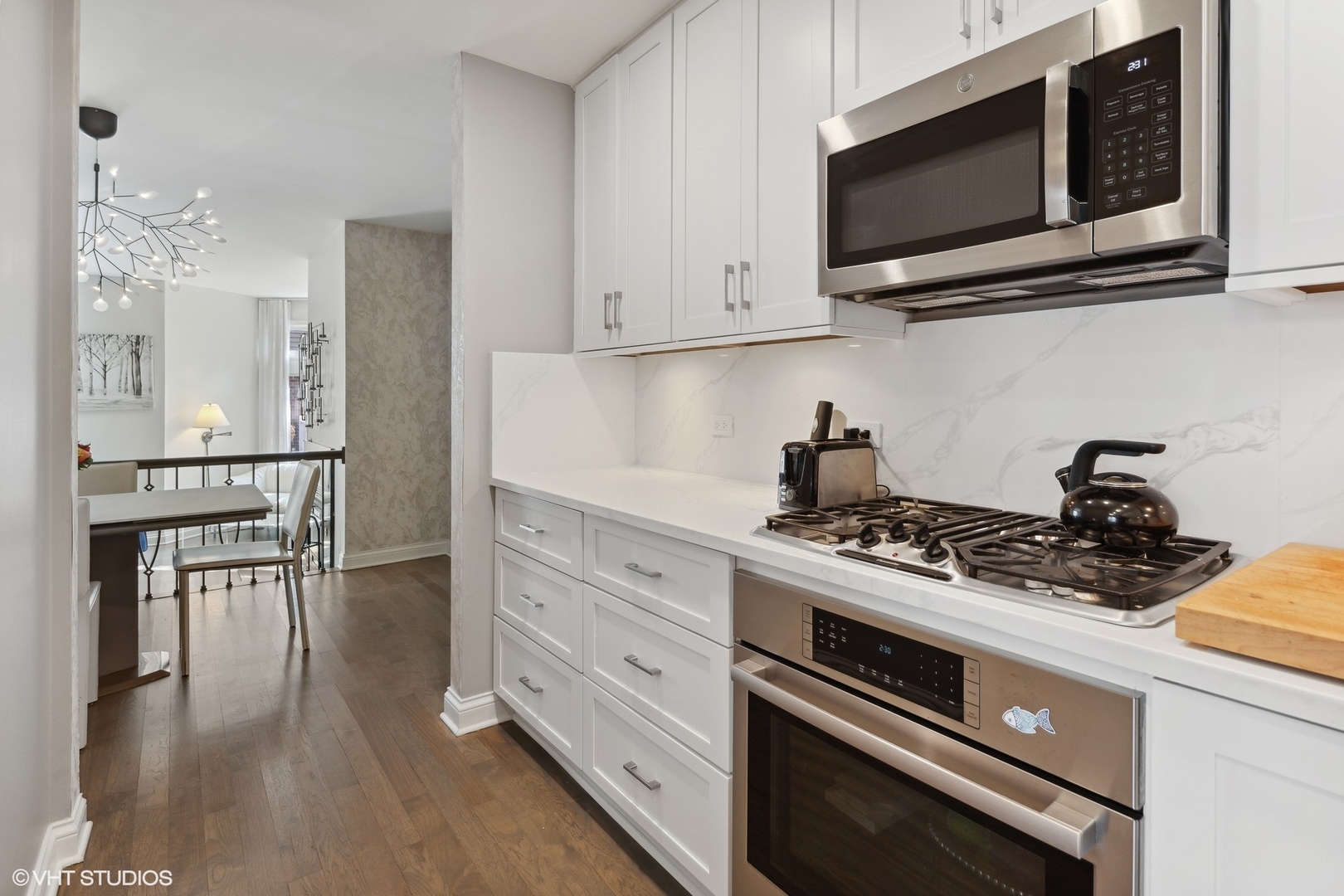 3305 North Racine Avenue, Unit E Chicago, IL 60657 - Photo 10 of 30 a kitchen with stainless steel appliances a stove a microwave and cabinets