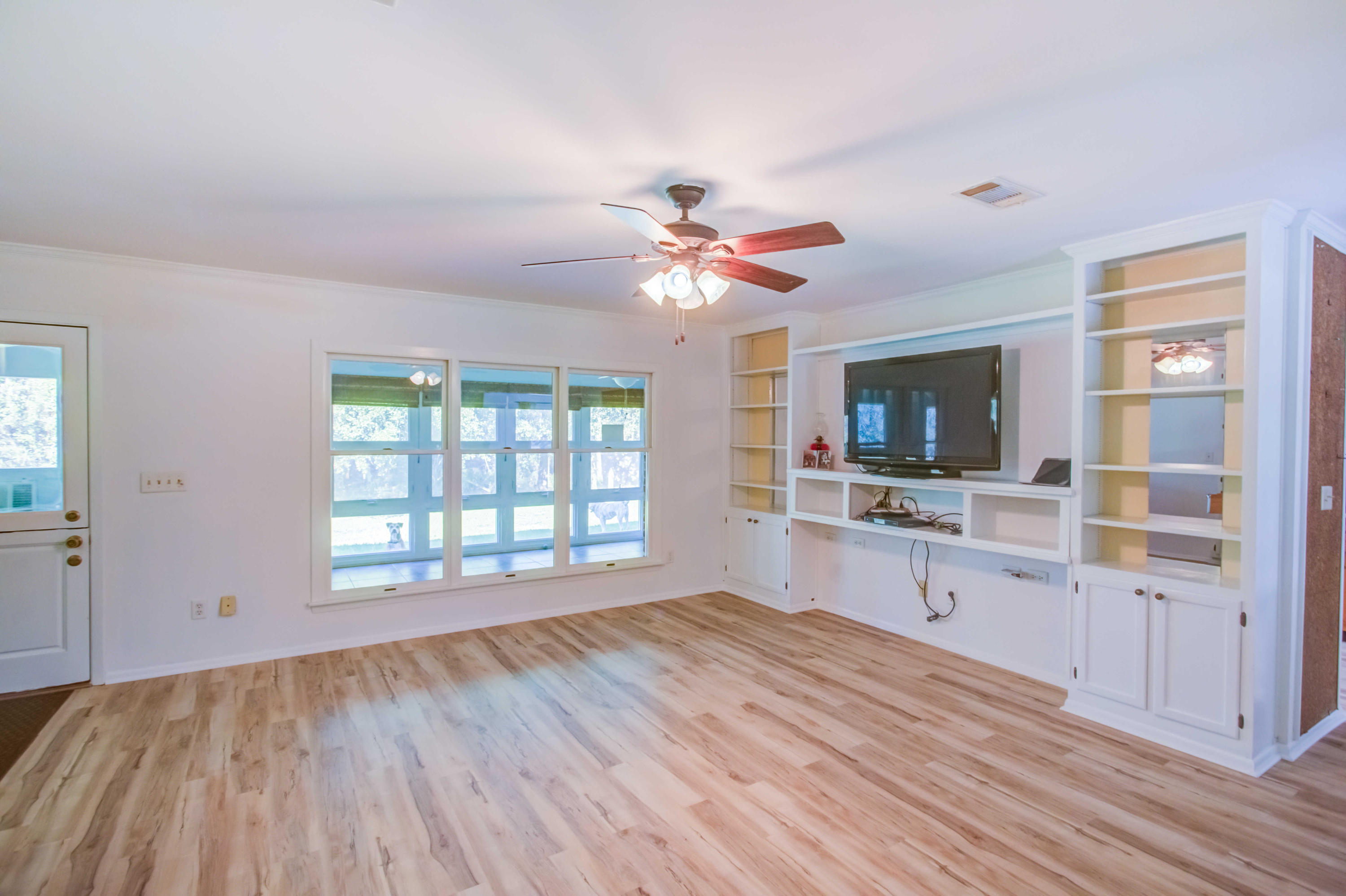 6116 Pine Ridge Lane Crestview, FL 32539 - Photo 13 of 45 a view of an empty room with window and wooden floor