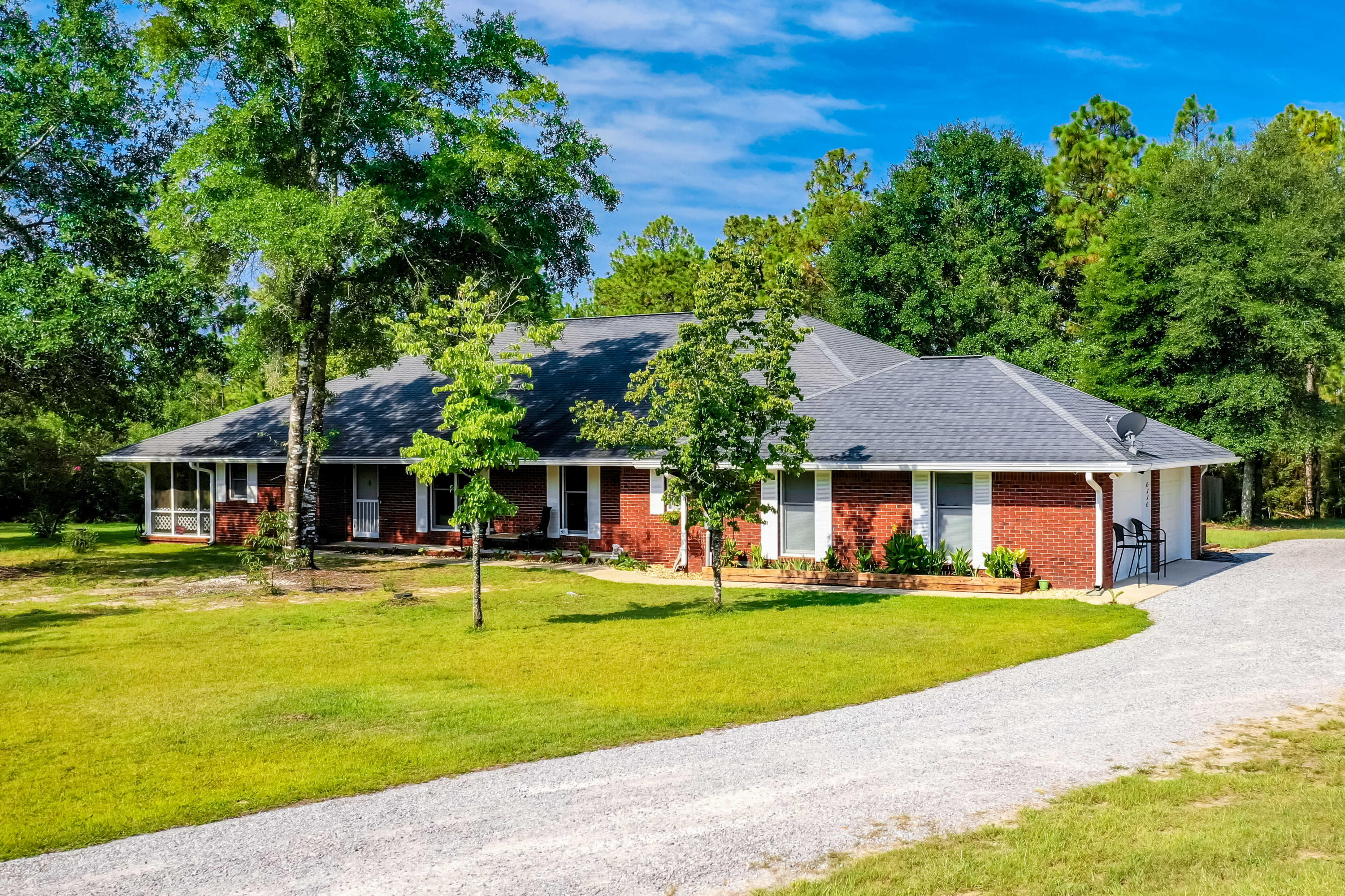6116 Pine Ridge Lane Crestview, FL 32539 - Photo 10 of 45 a front view of a house with a yard table and chairs