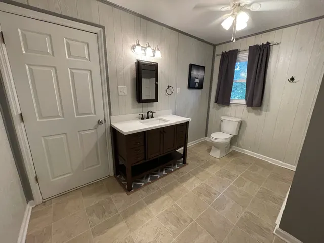 a spacious bathroom with a toilet sink and mirror