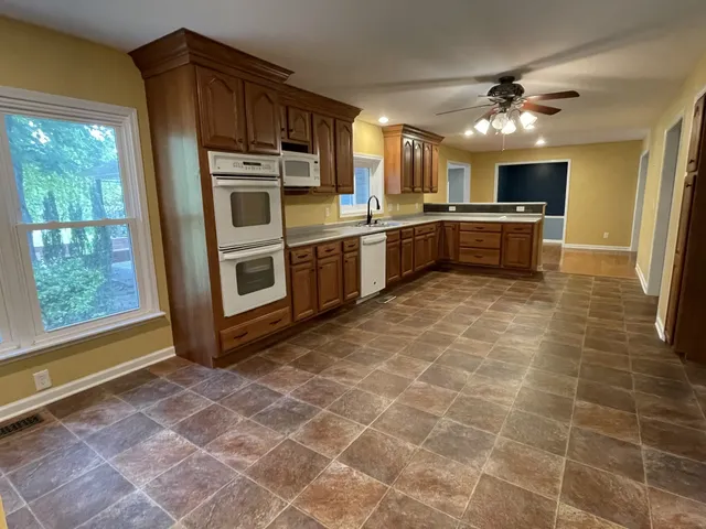a kitchen with stainless steel appliances granite countertop a stove a sink and a microwave
