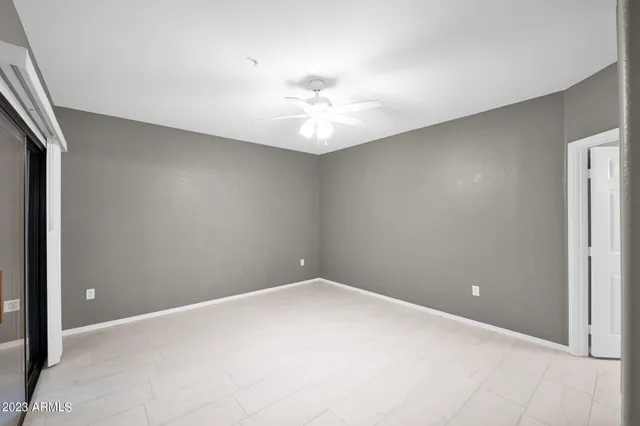 an empty room with a ceiling fan and carpet