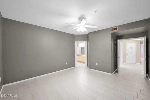 a view of an empty room with a chandelier fan