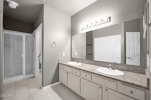 a bathroom with double sink and a mirror