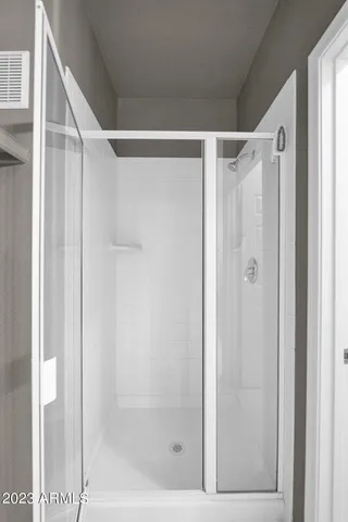 a bathroom with a shower and a glass door