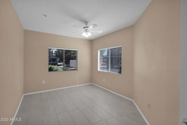 a view of an empty room with wooden floor and windows