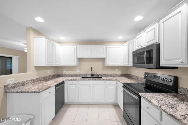 a kitchen with stainless steel appliances granite countertop a sink stove a microwave and cabinets