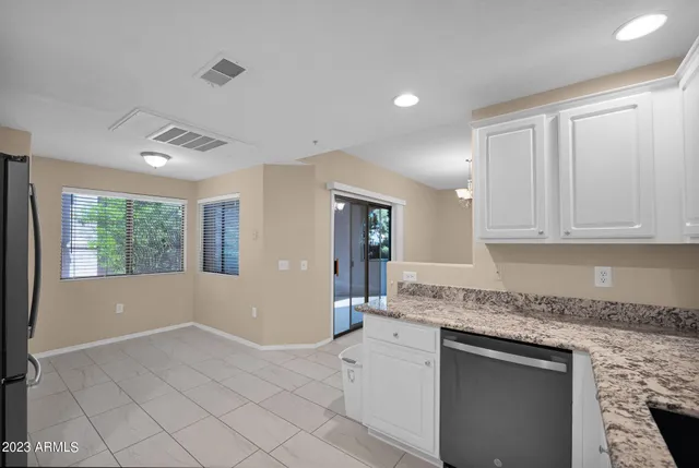 a kitchen with granite countertop white cabinets and white appliances